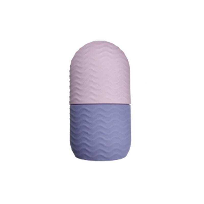 Rouleau de glace en silicone bicolore rose et violet, à motif ondulé, posé debout sur fond neutre