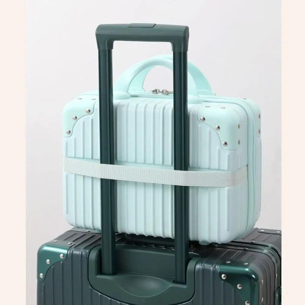Mini valise rigide fixée à la poignée télescopique d’une valise cabine grâce à sa sangle arrière intégrée