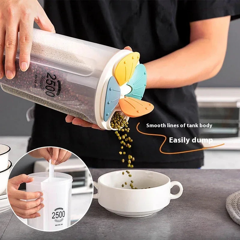 Boîte alimentaire 4 compartiments 2,5L en plastique, avec couvercle rotatif coloré – démonstration du versement facile de graines dans un bol grâce au bec verseur intégré.