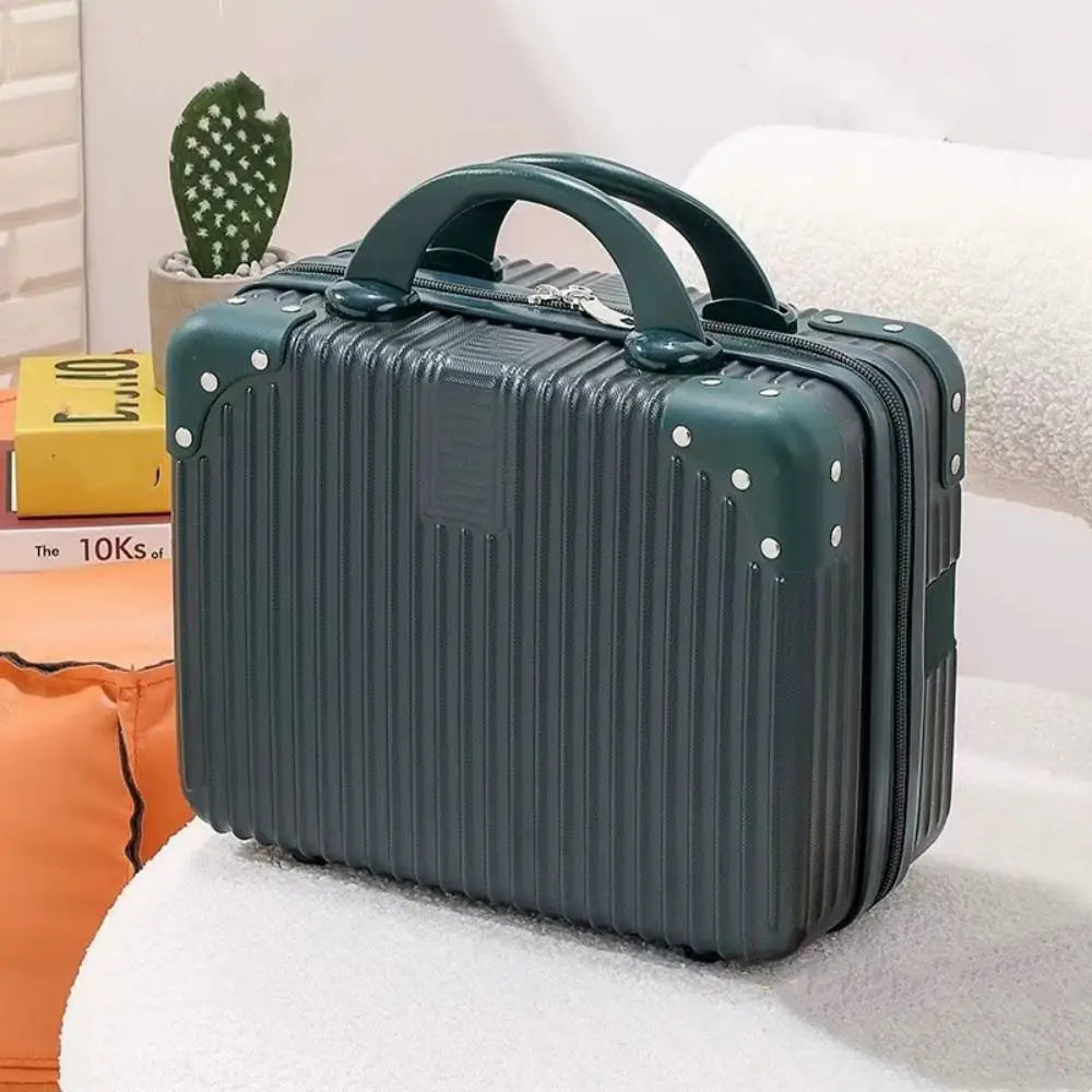 Mini valise rigide verte sapin posée sur un canapé blanc, avec poignée renforcée et coins rivetés, parfaite pour accessoires et cosmétiques