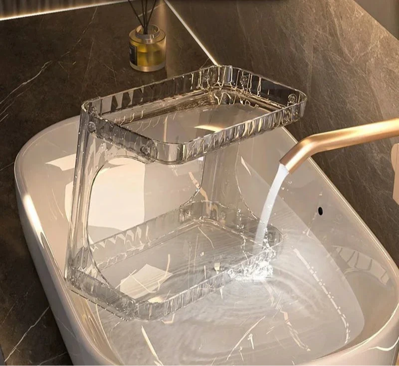 Support de rangement cosmétique en acrylique transparent rincé à l’eau dans un lavabo – matériau résistant à la rouille et facile à nettoyer, idéal pour un usage en salle de bain.