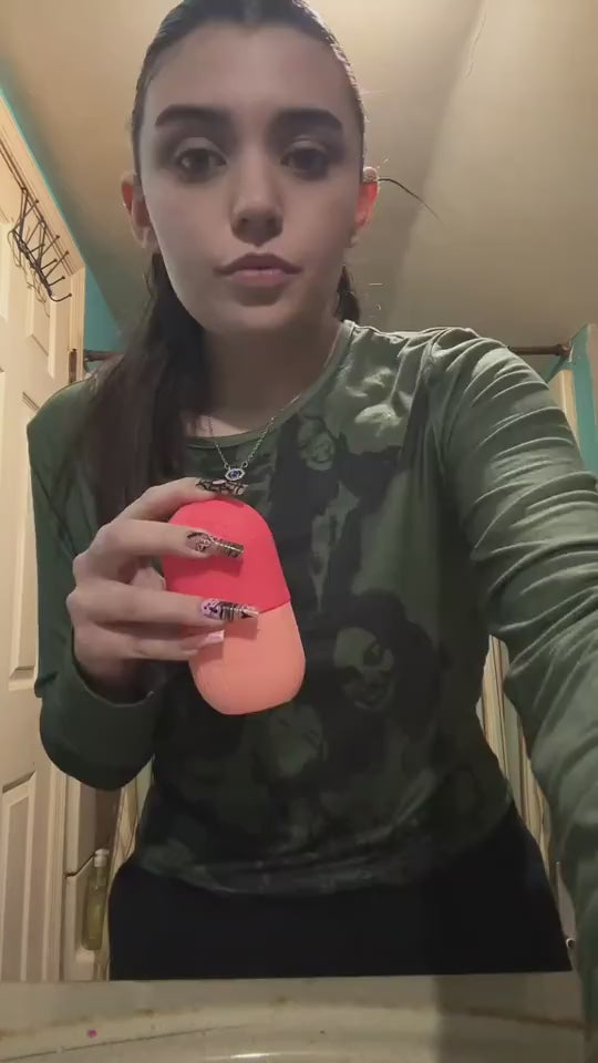 Vidéo démonstrative d'une femme utilisant un rouleau de glace en silicone orange pour le visage, tenue à la main avant application