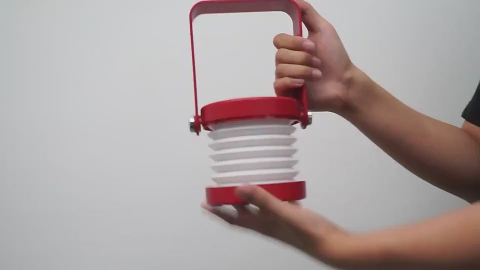 Démonstration de la lampe LED pliable rouge – design nomade avec poignée, éclairage modulable et format compact pour lecture, bureau ou camping.